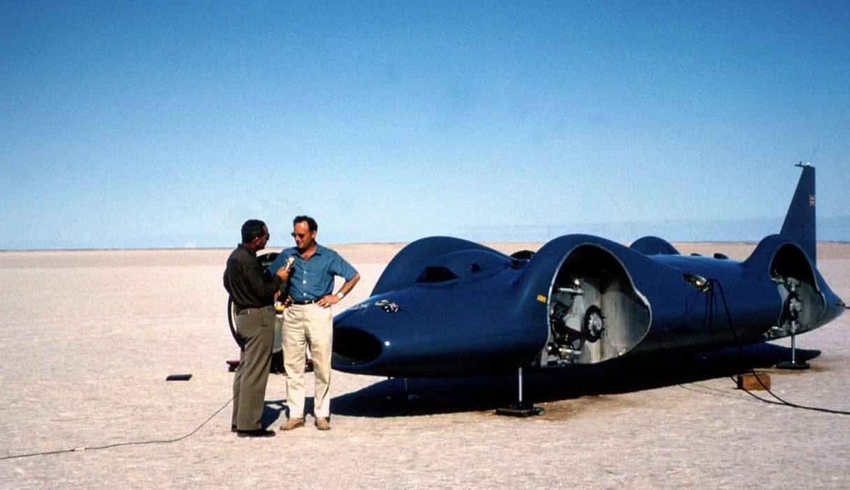 Donald Campbell being interviewed in front of Bluebird CN7, 1964. Lake Eyre, Australia. By National Motor Museum.